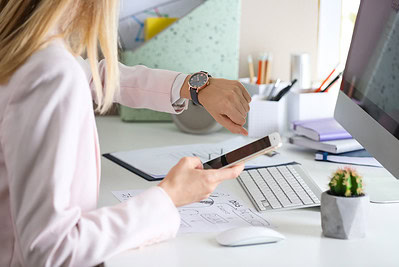 Frau arbeitet im Homeoffice mit Computer und Handy