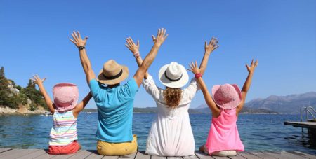 glückliche Familie streckt Arme in den blauen Himmel