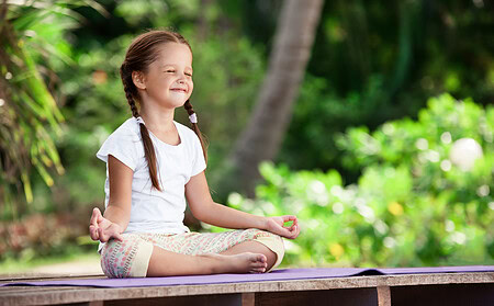 meditierendes Mädchen im Garten genießt die Wirkung der Meditation